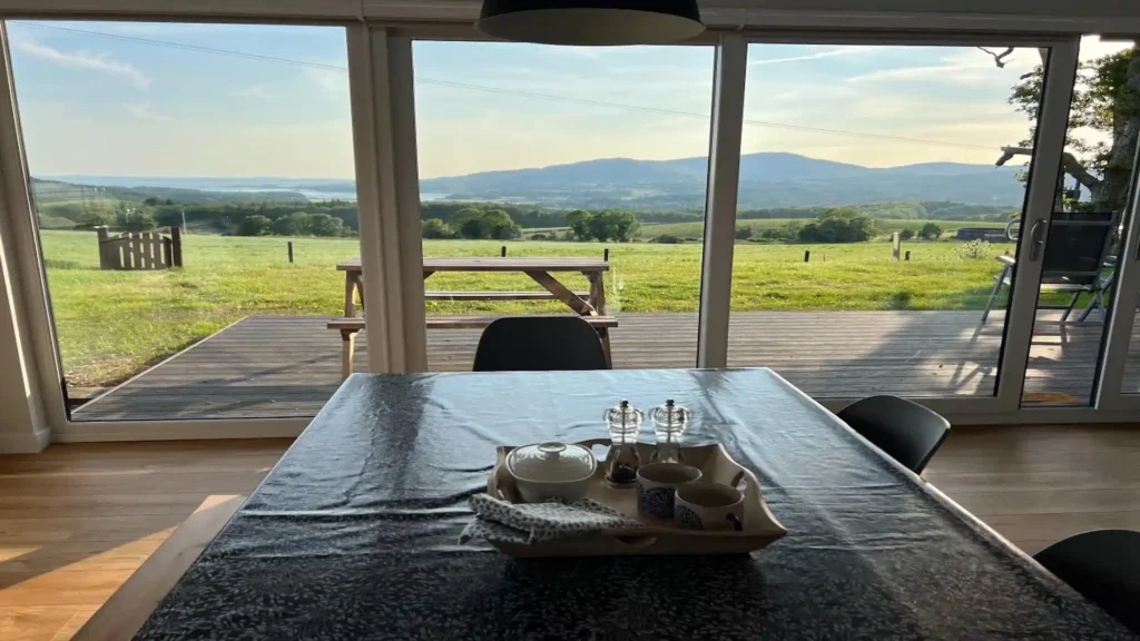 Dining table inside a luxury lodge overlooking open countryside in Dumfries and Galloway